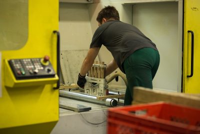Nahaufnahme von einem Menschen der eine mechanische Maschine bedient